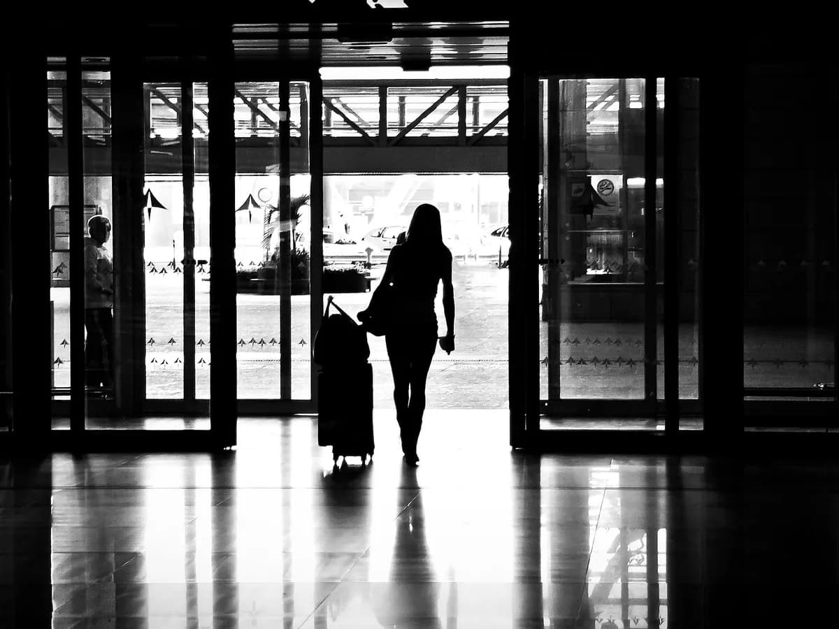 Putnica s koferom izlazi iz zgrade aerodroma