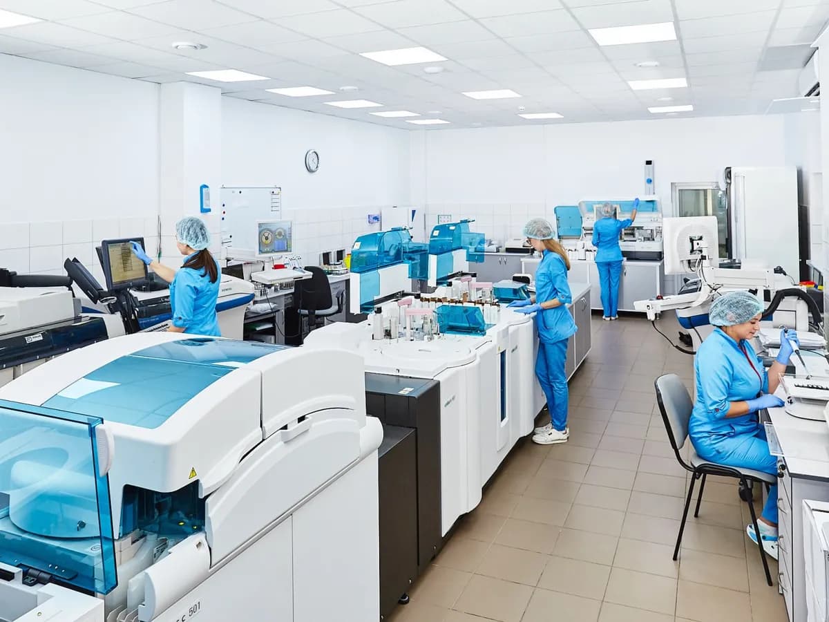 Naučnici u laboratorijskim mantilima rade s uzorcima i mikroskopima