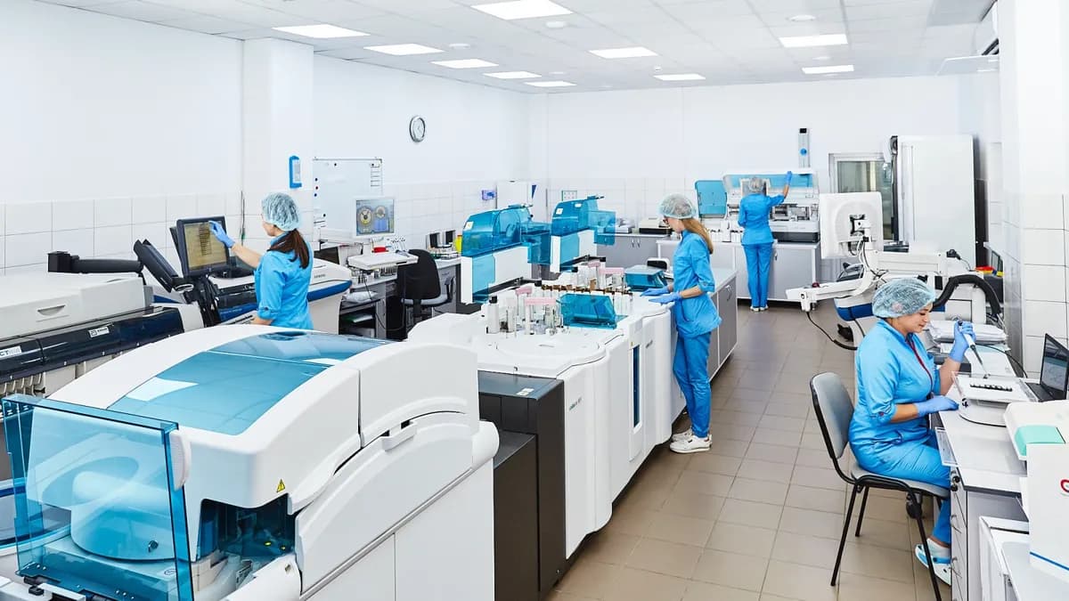Naučnici u laboratorijskim mantilima rade s uzorcima i mikroskopima