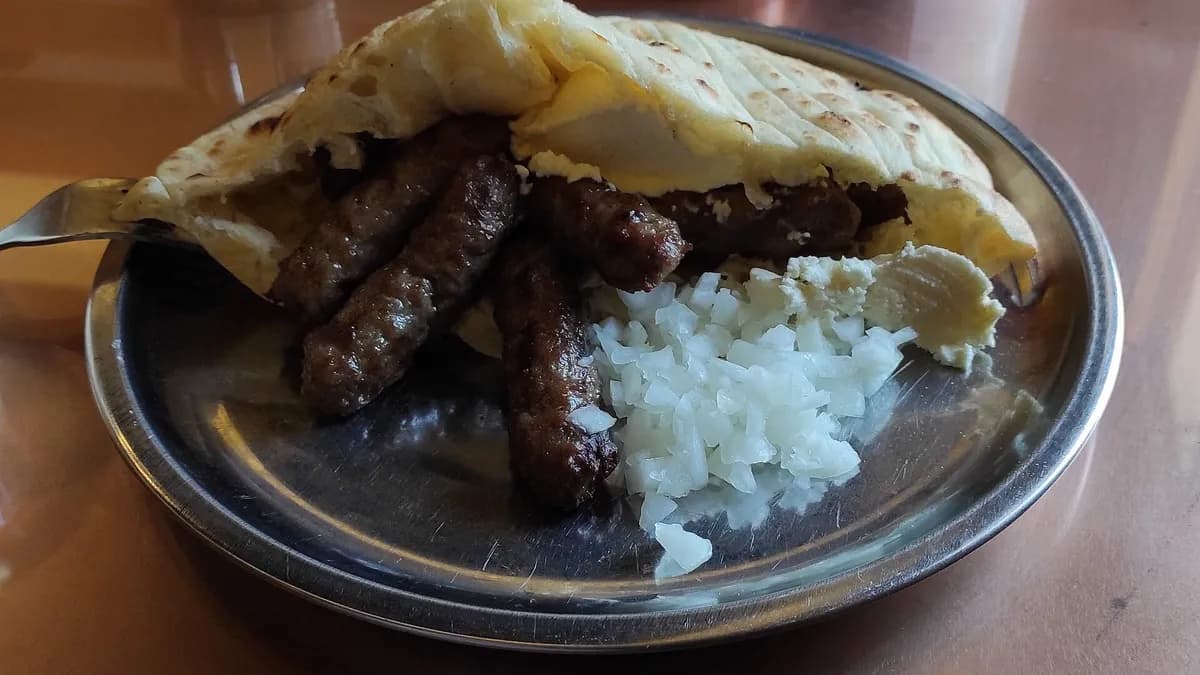 Ćevapi u somunu s kajmakom i lukom