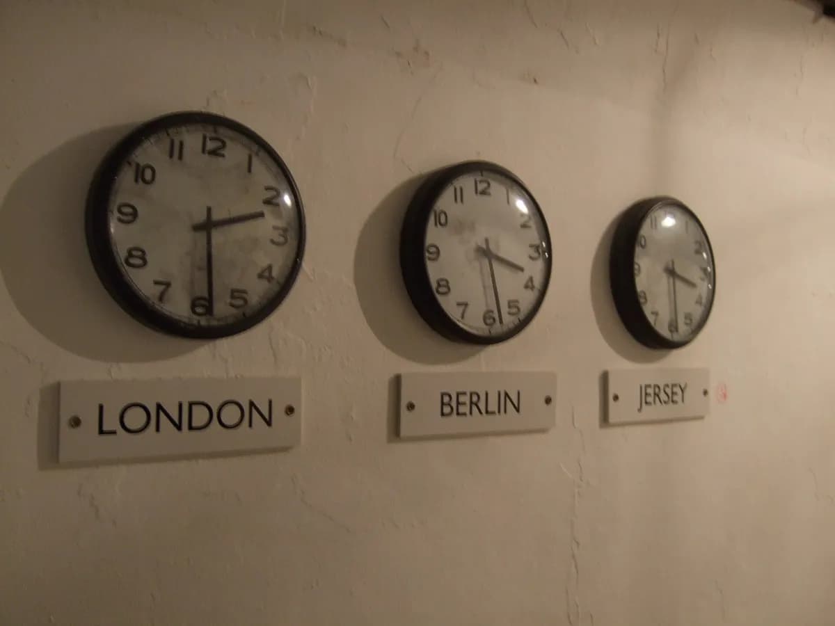 Tri zidna sata s natpisima London, Berlin i Jersey koji pokazuju različito vrijeme