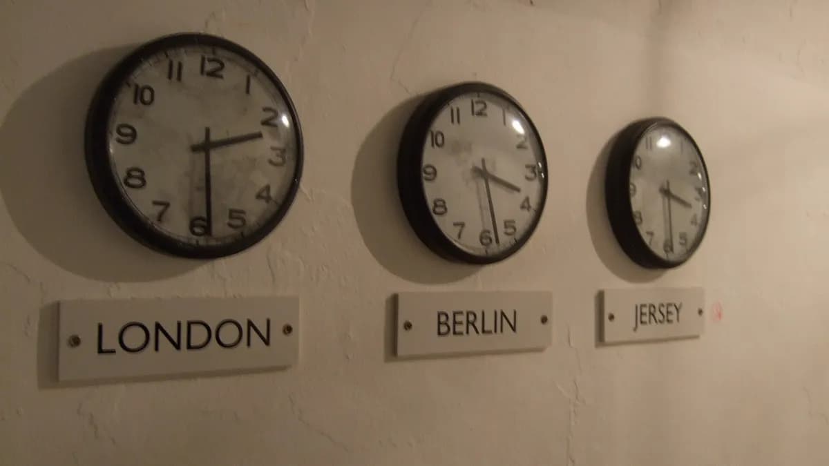 Tri zidna sata s natpisima London, Berlin i Jersey koji pokazuju različito vrijeme