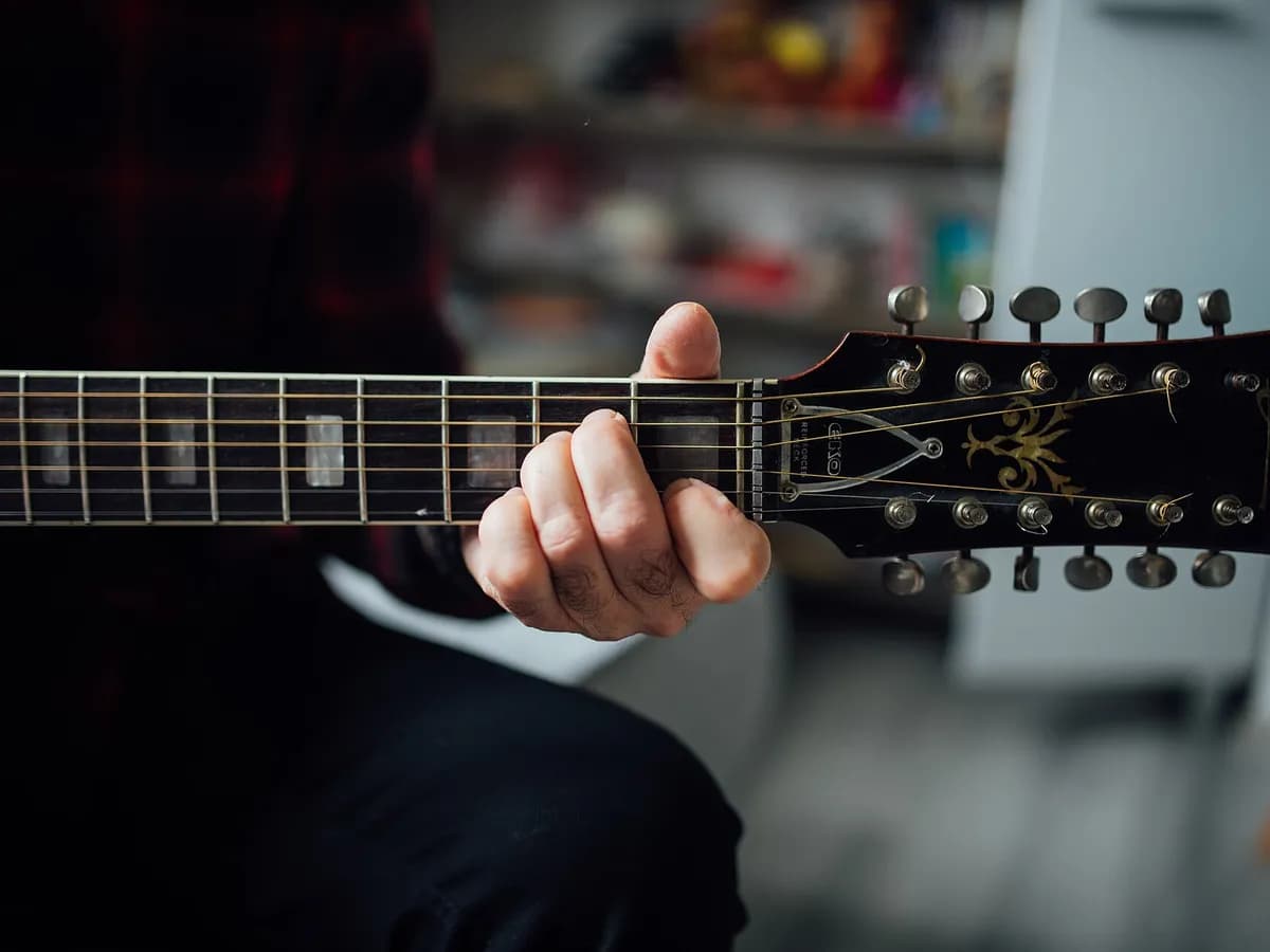 Šaka hvata A-mol akord na vratu akustične gitare