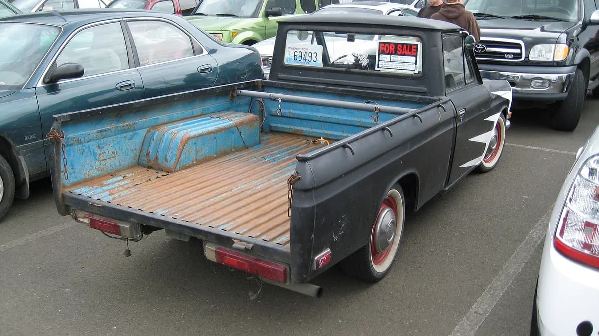 Polovni automobil s natpisom o prodaji na parkingu